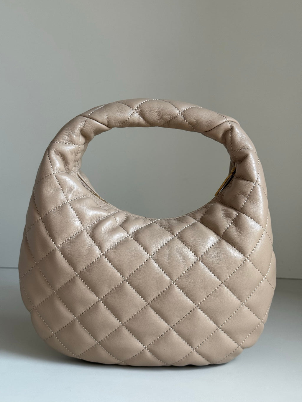 YSL quilted hobo bag in light beige with diamond stitching and rounded silhouette