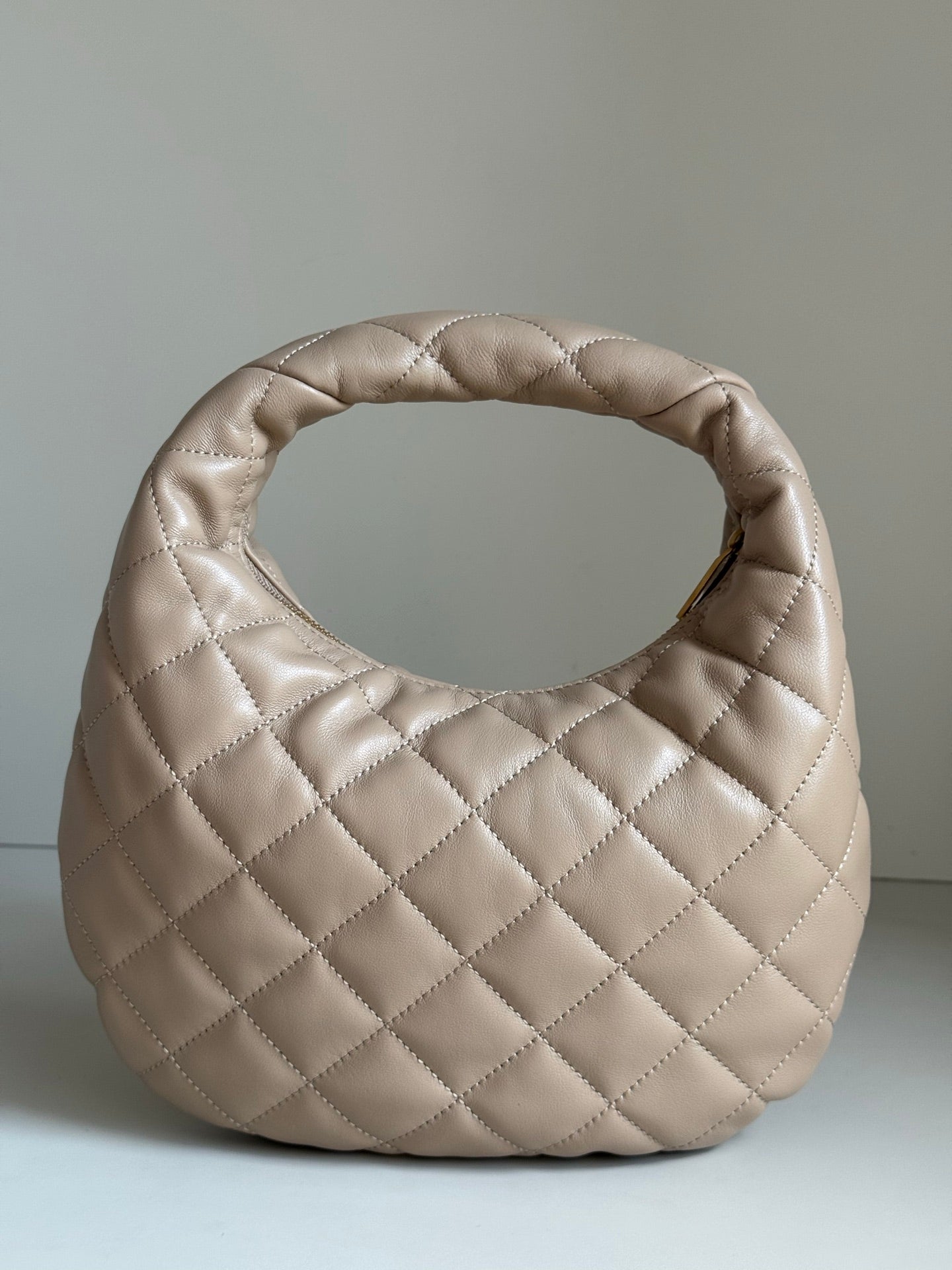 YSL quilted hobo bag in light beige with diamond stitching and rounded silhouette