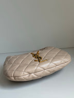 YSL quilted hobo bag side view with gold YSL logo charm and handle hardware