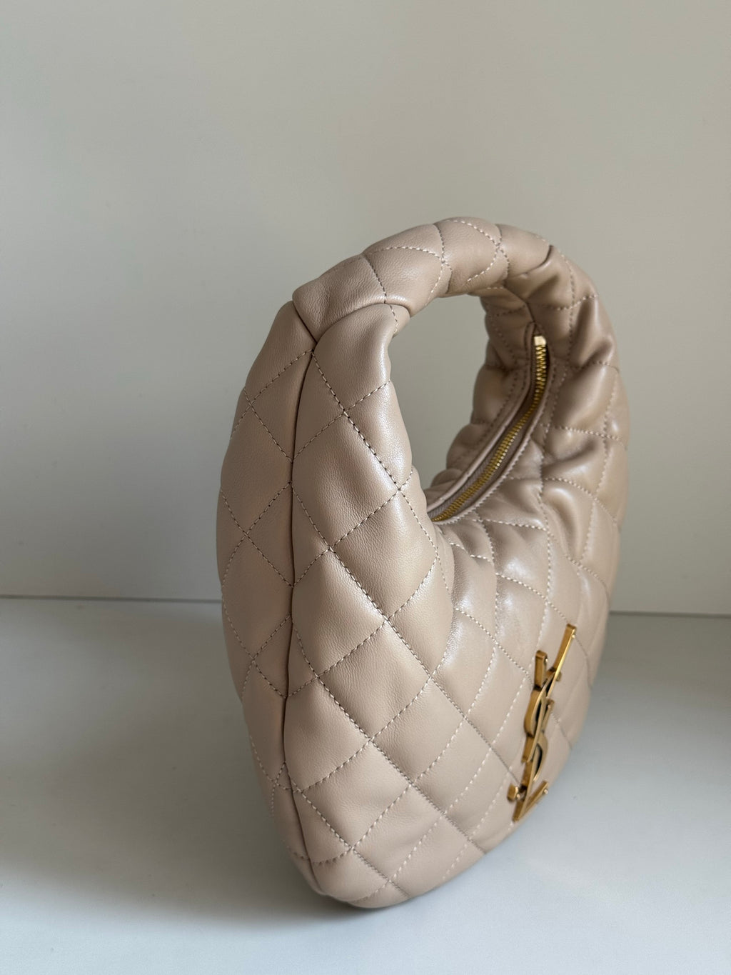 YSL quilted hobo bag showing top handle and rear opening with gold zipper pull