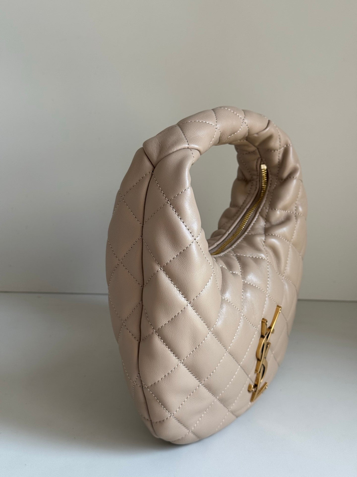 YSL quilted hobo bag showing top handle and rear opening with gold zipper pull