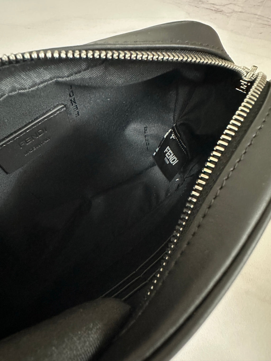 Fendi bag interior close-up with inner logo label and silver zipper track