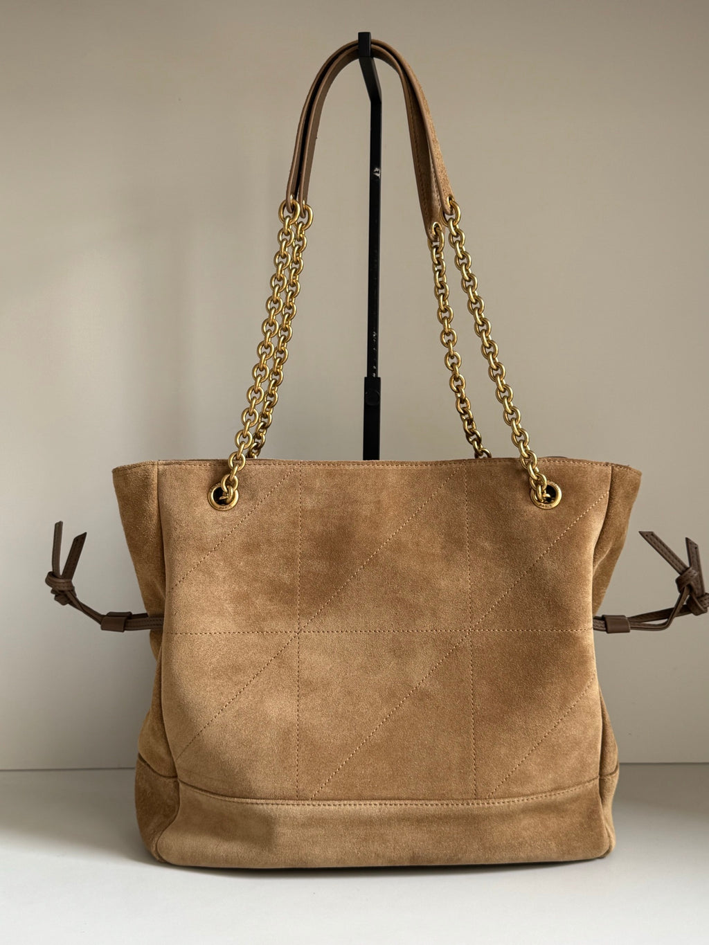 Tan suede tote bag with gold chain shoulder straps and top handles, front view