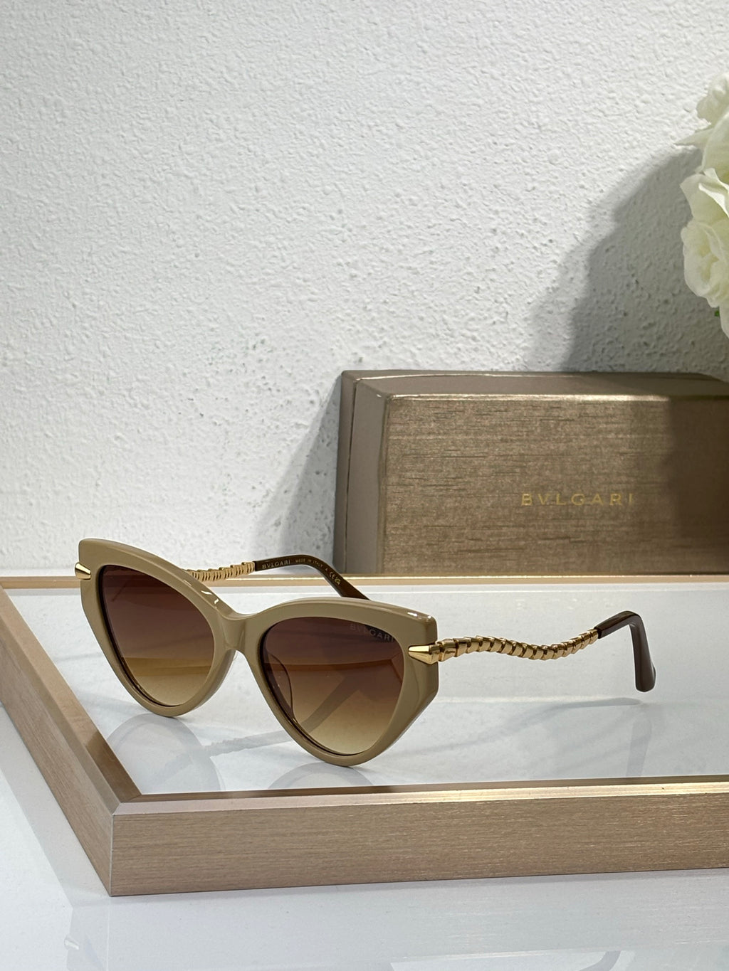 Bvlgari sunglasses with tan frames, brown lenses, and braided gold temple cords
