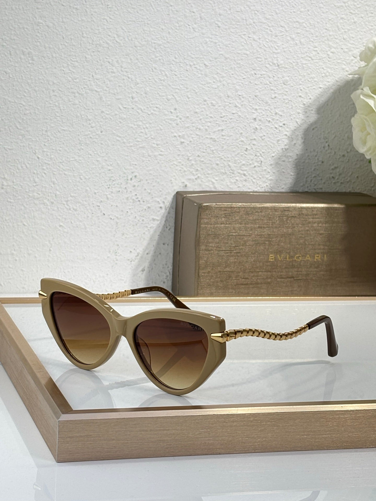 Bvlgari sunglasses with tan frames, brown lenses, and braided gold temple cords