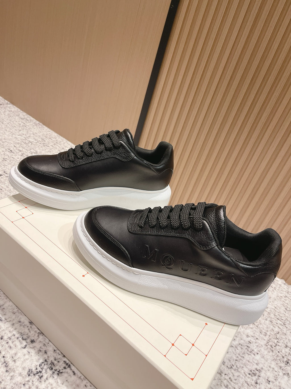 Alexander McQueen lace-up sneakers with black uppers and white rubber sole