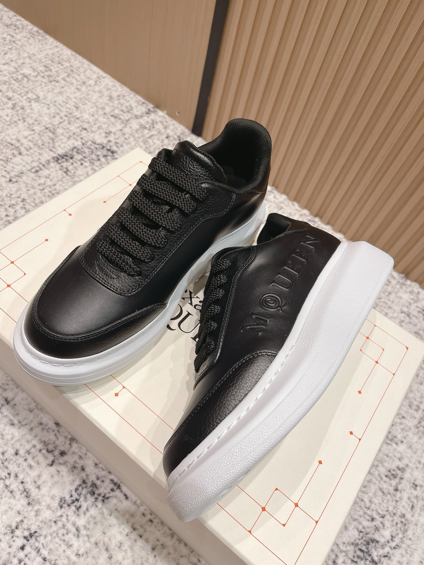 Alexander McQueen lace-up sneakers showing black tongue lining and white platform sole