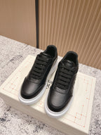 Alexander McQueen lace-up sneakers in black leather with white rubber sole