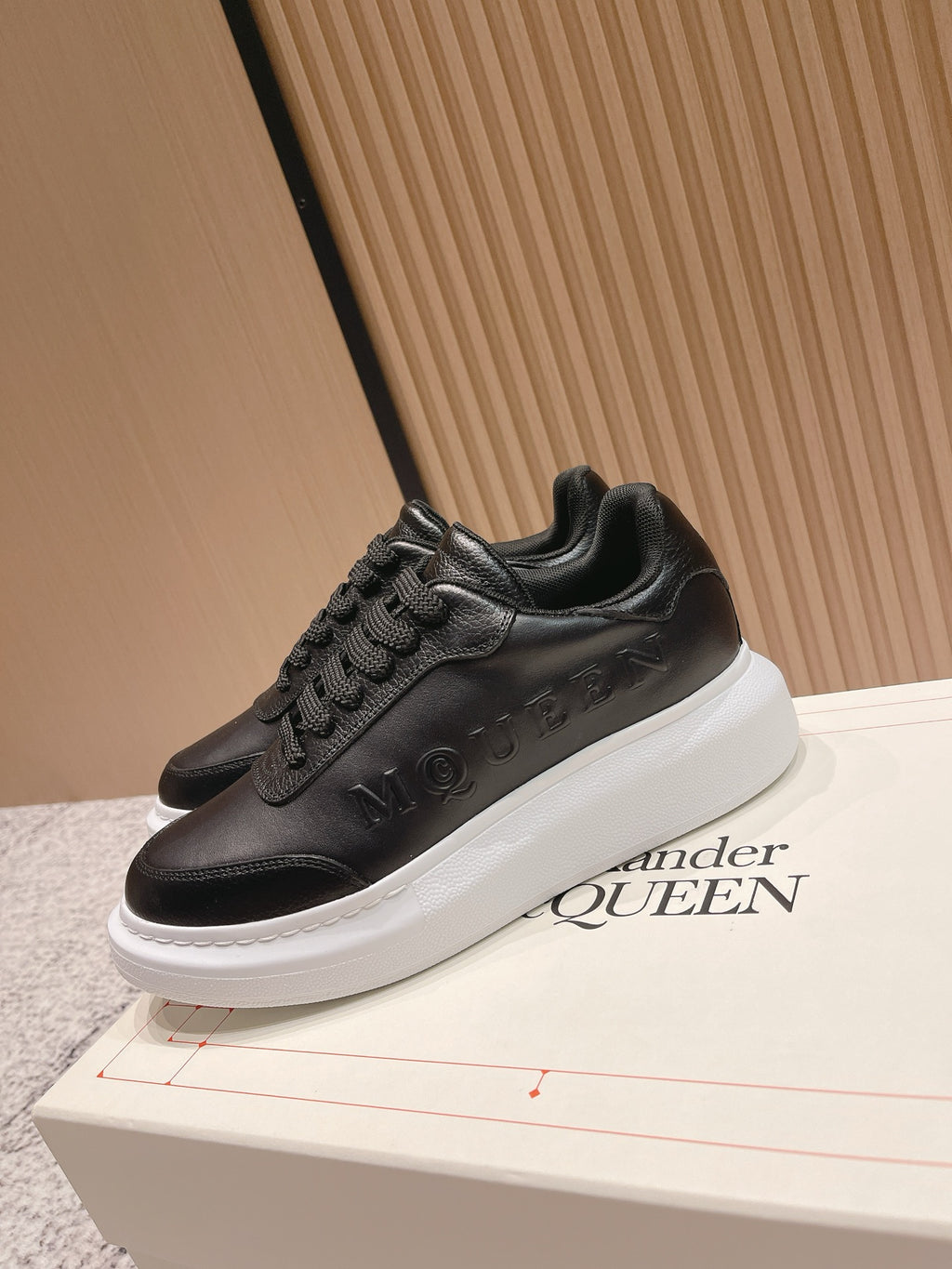 Alexander McQueen lace-up sneakers in black leather with white midsole and branding