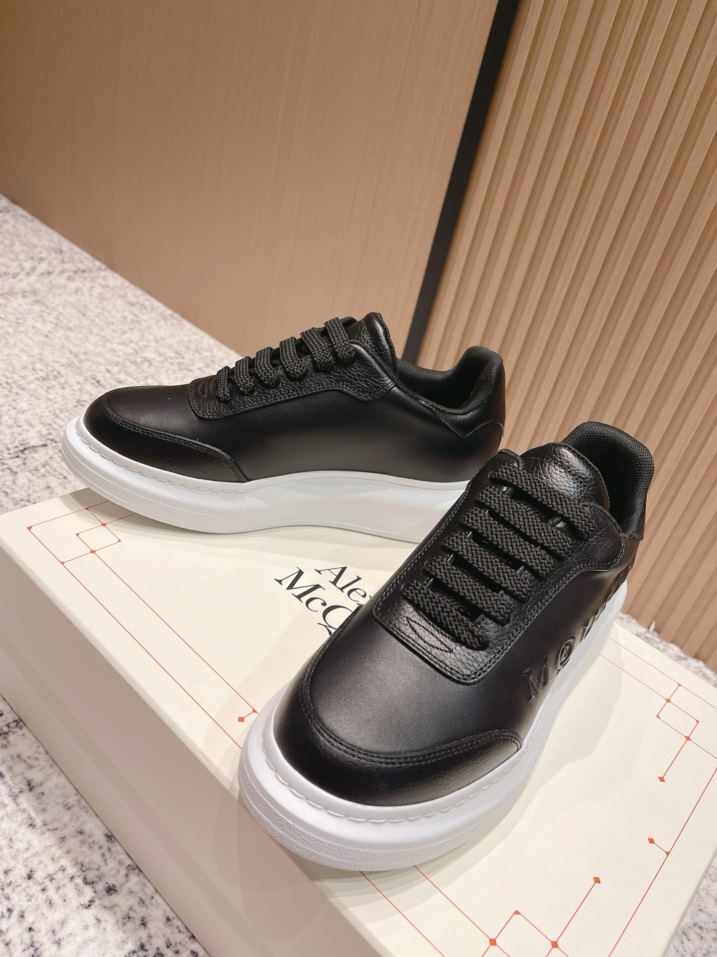 Alexander McQueen low-top lace-up sneakers in black with textured panel and white sole