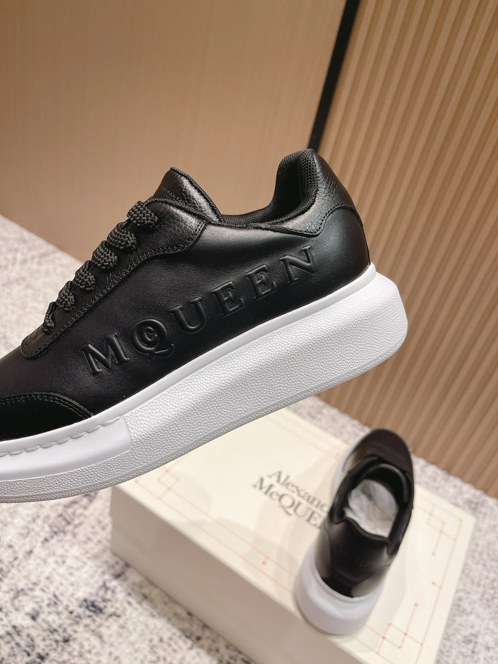 Alexander McQueen lace-up sneakers in black with embossed MQ branding on side