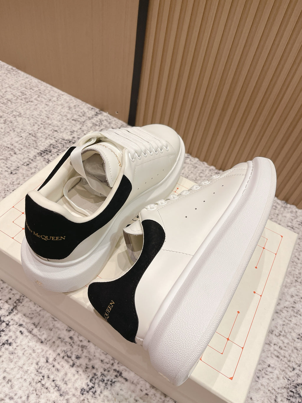 White lace-up sneakers with black interior lining and black heel tab, side view