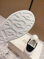 White sneaker outsole with textured tread, on Alexander McQueen shoebox