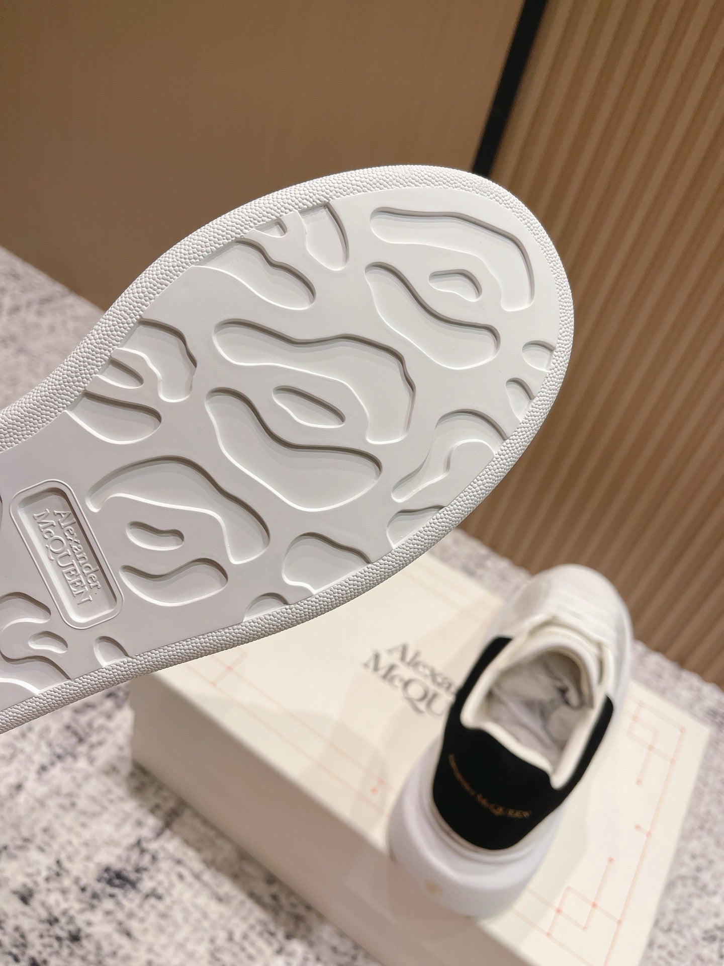 White sneaker outsole with textured tread, on Alexander McQueen shoebox