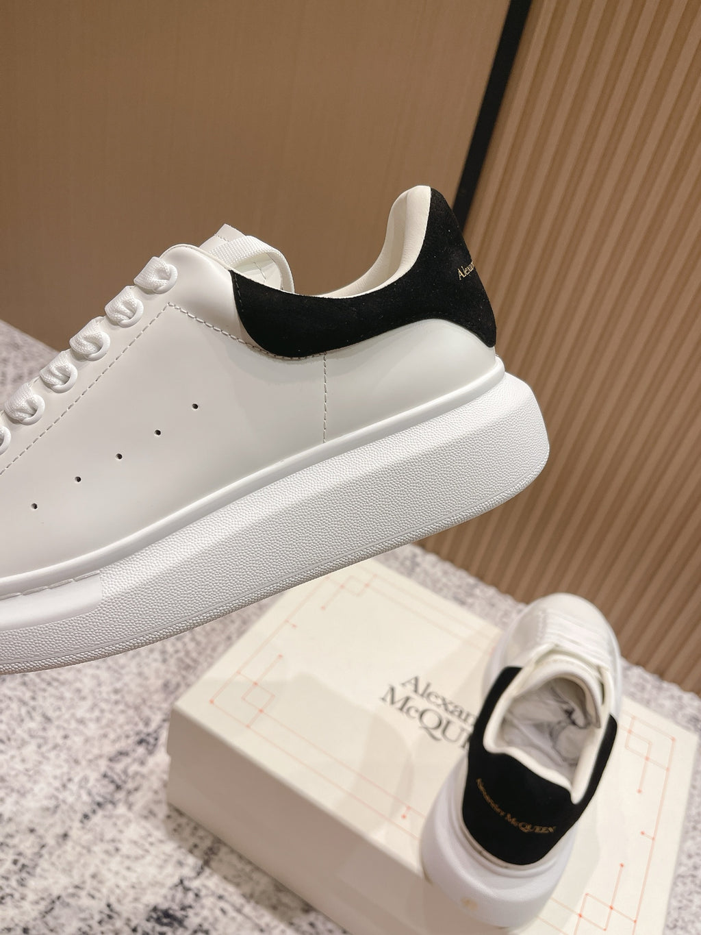White sneaker profile with black heel tab and thick rubber sole, side view