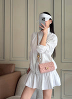 Chanel pink quilted mini shoulder bag worn with gold-tone chain strap