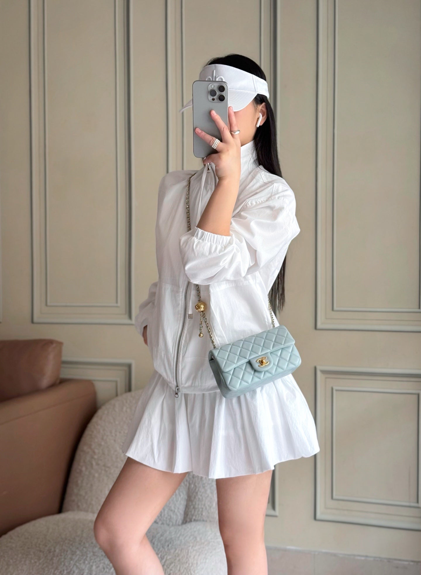 Chanel quilted light blue mini bag worn crossbody with gold chain strap