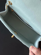 Chanel light blue quilted shoulder bag open to show interior and gold zip pull