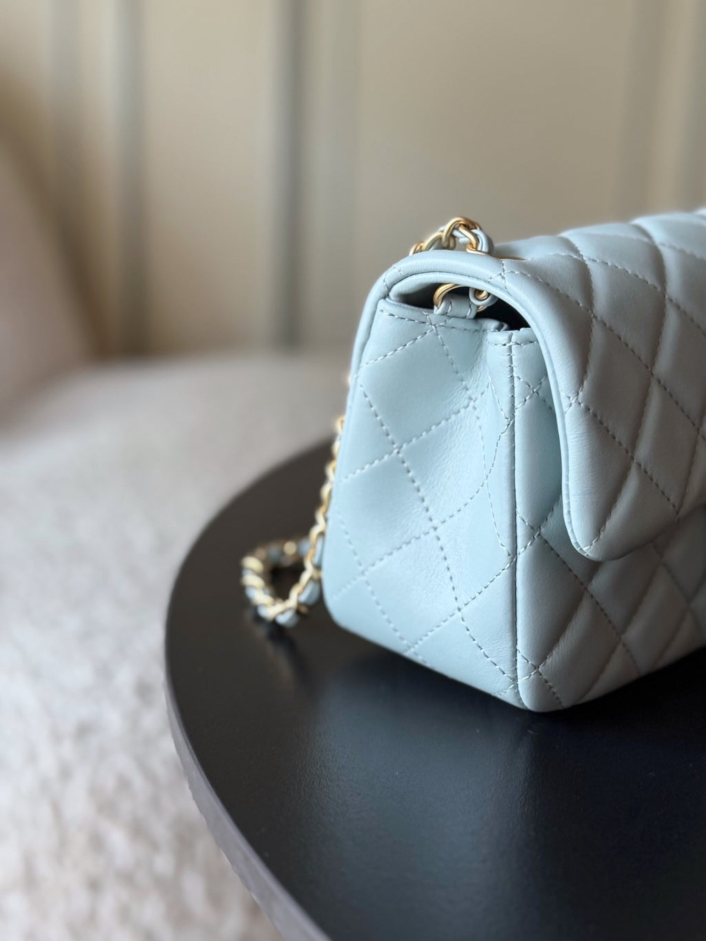Chanel quilted flap bag side view in light blue leather with gold chain strap
