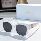 White acetate sunglasses with rounded cat-eye frames and dark gray tinted lenses, Dior detail