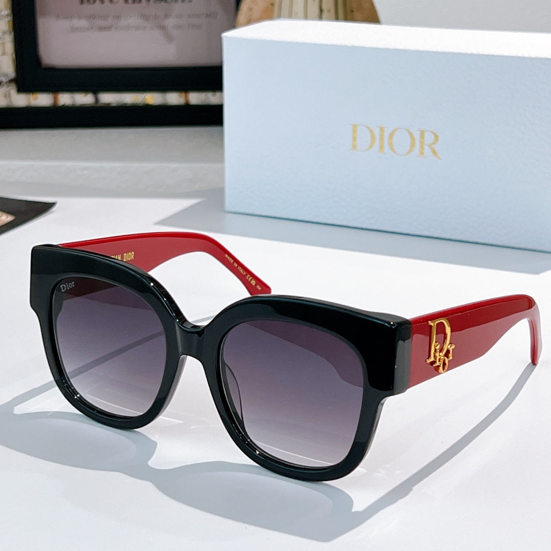 Black acetate sunglasses with rounded cat-eye frames, red arms, and dark tinted lenses, Dior detail