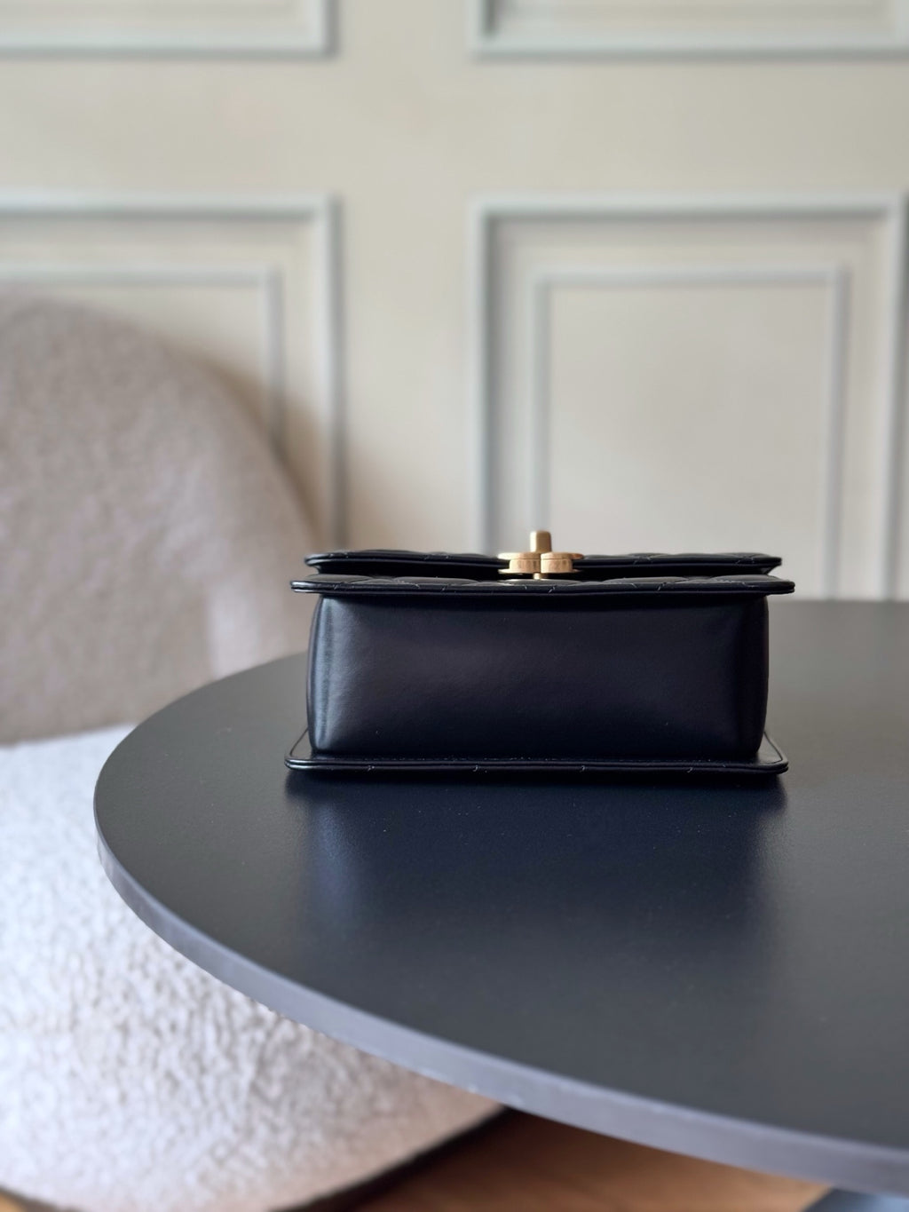 Black flap shoulder bag with hinged top and gold-tone hardware