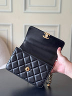 Black quilted crossbody flap bag held in hand with gold CC emblem