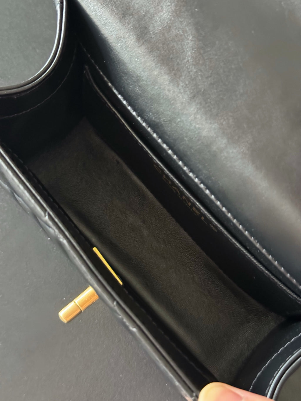 Interior view of black shoulder bag with double compartment and gold zipper pull