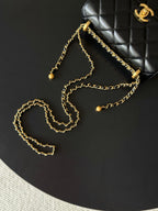 Black quilted shoulder bag with gold chain strap and bead details