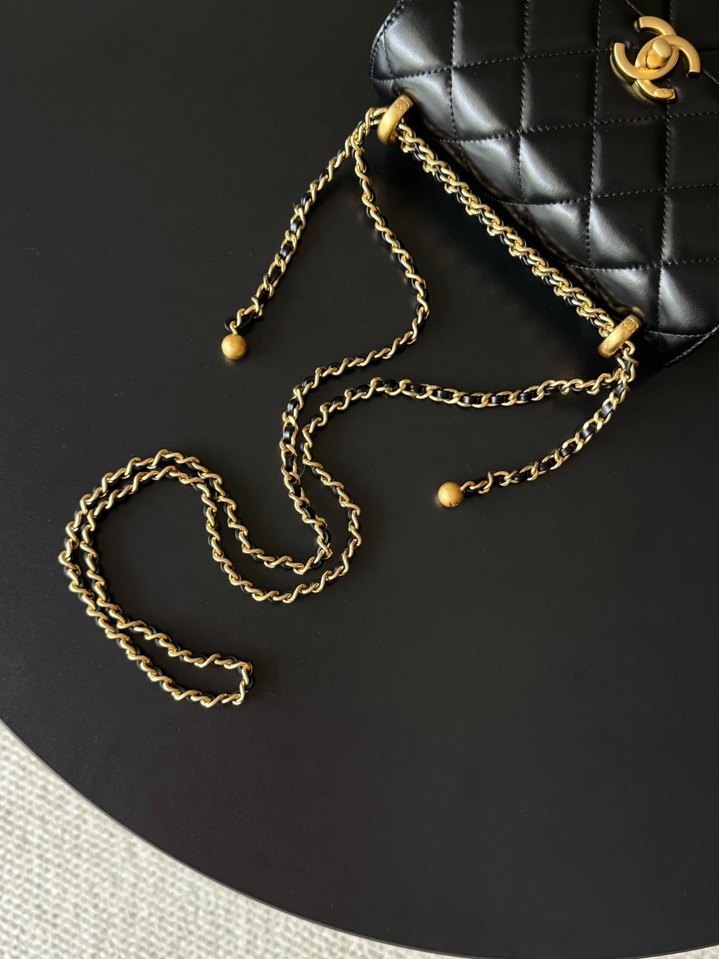 Black quilted shoulder bag with gold chain strap and bead details