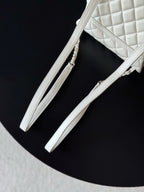 Chanel white quilted bag with chain shoulder straps and slim leather handle.