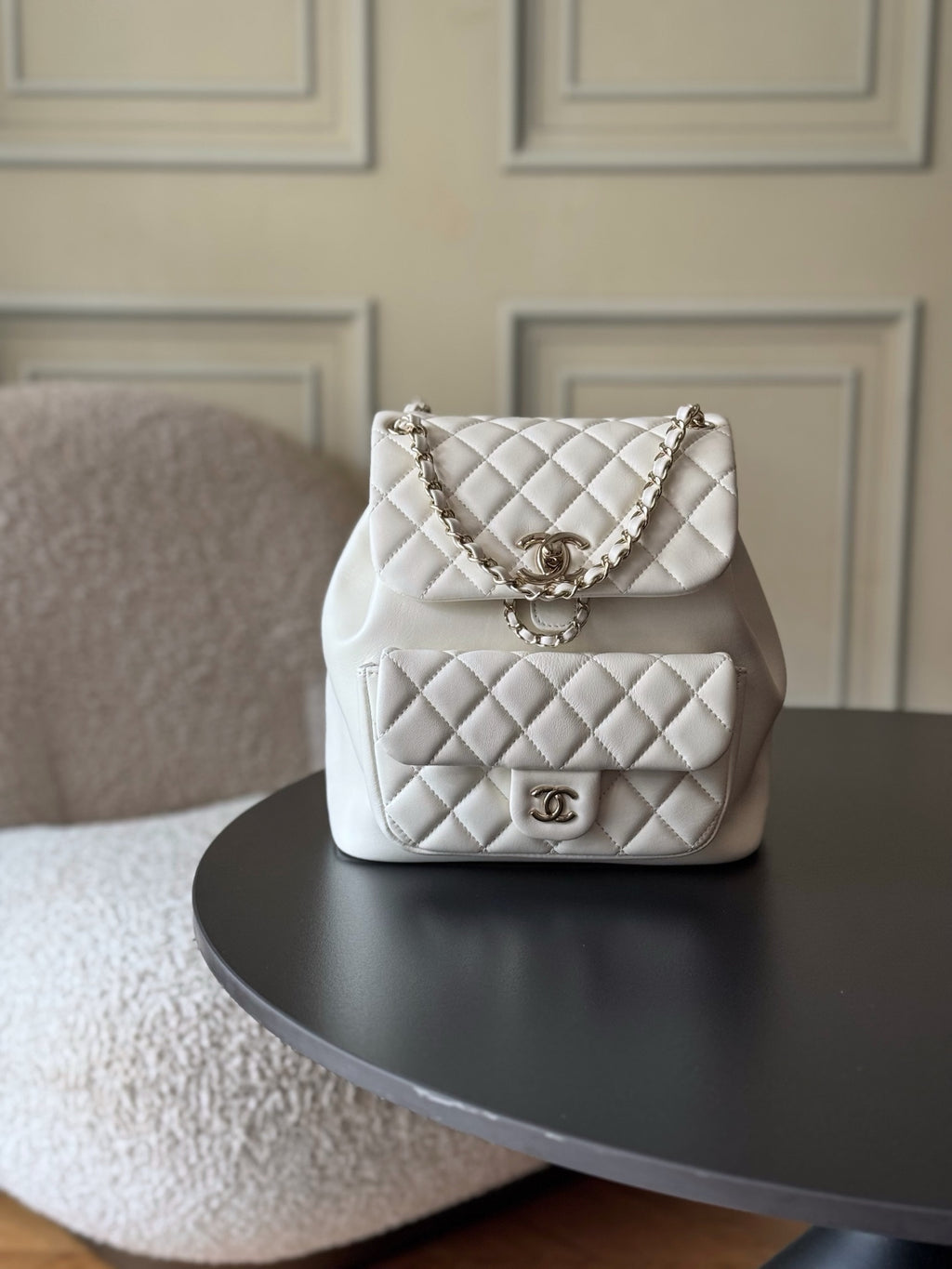 Chanel quilted white shoulder bag with chain strap and front logo clasp.