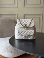 Chanel quilted white shoulder bag with chain strap and front logo clasp.