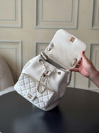 Chanel quilted white shoulder bag with chain strap, CC emblem and metal lock.