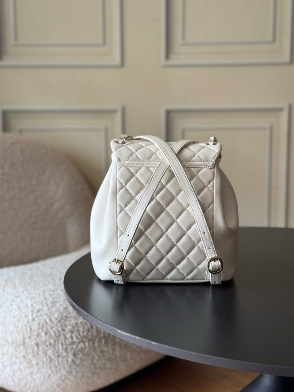 Chanel quilted white bucket bag with chain straps and top hardware.