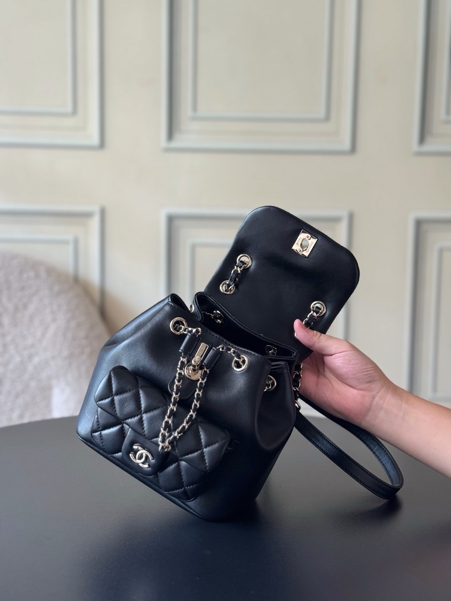 Chanel quilted leather mini bag held in hand with chain strap and wristlet strap