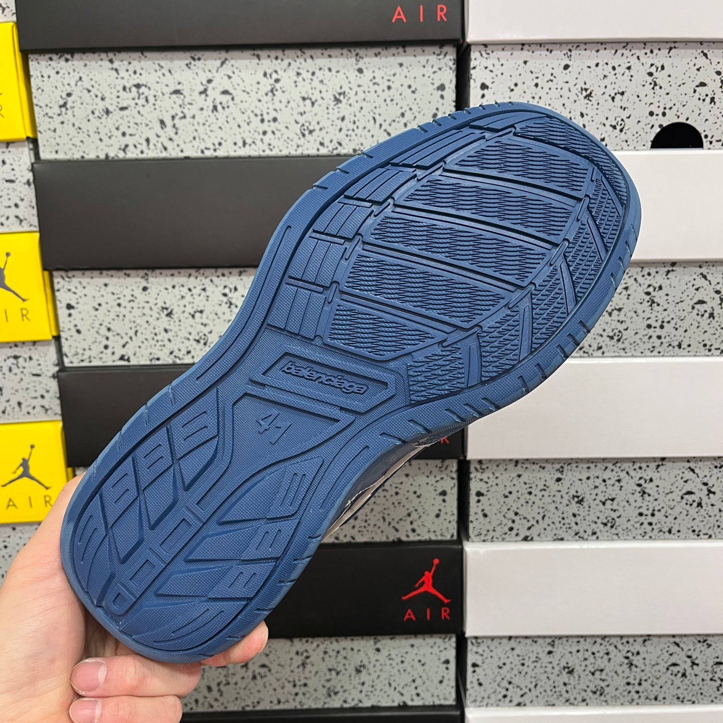 Blue sneaker outsole with patterned tread and embossed design