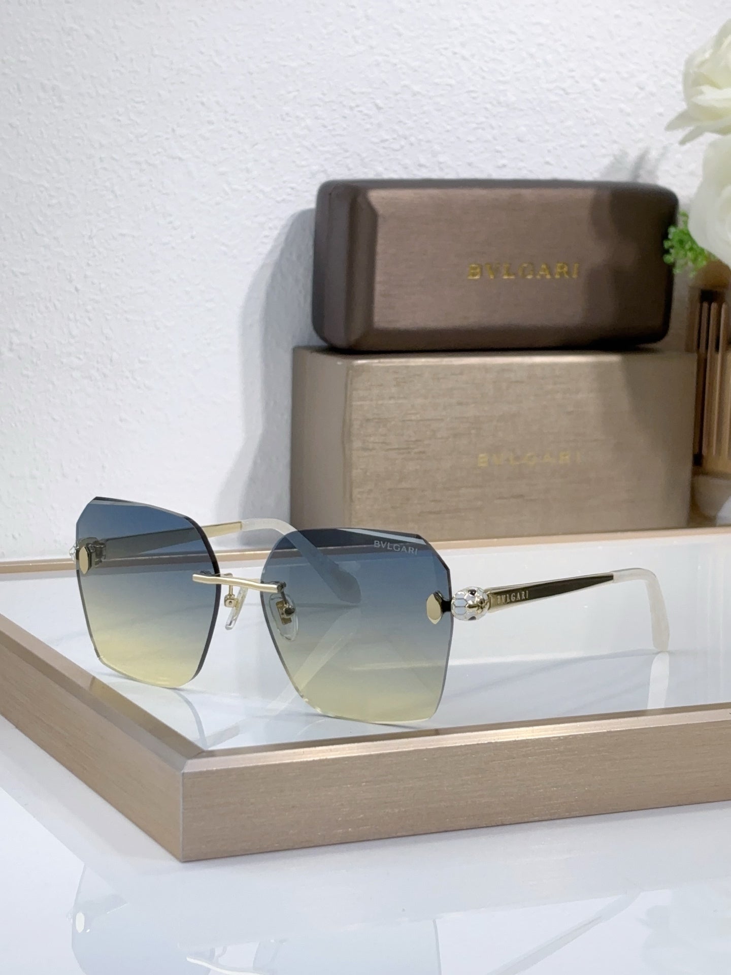 Bvlgari sunglasses with light blue gradient lenses and gold-tone metal frame