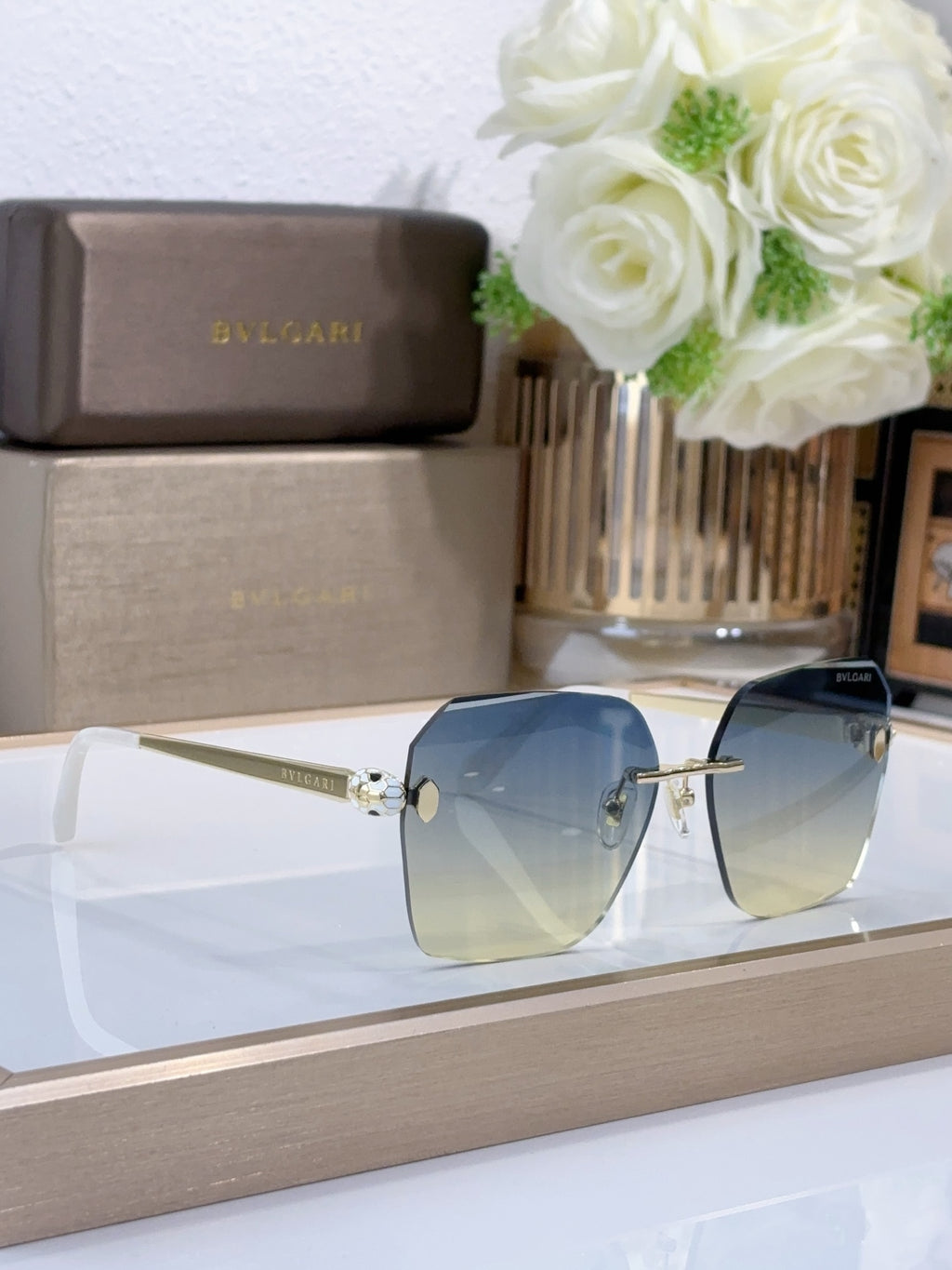 Bvlgari sunglasses with blue gradient lenses and gold-tone metal frame, side angle