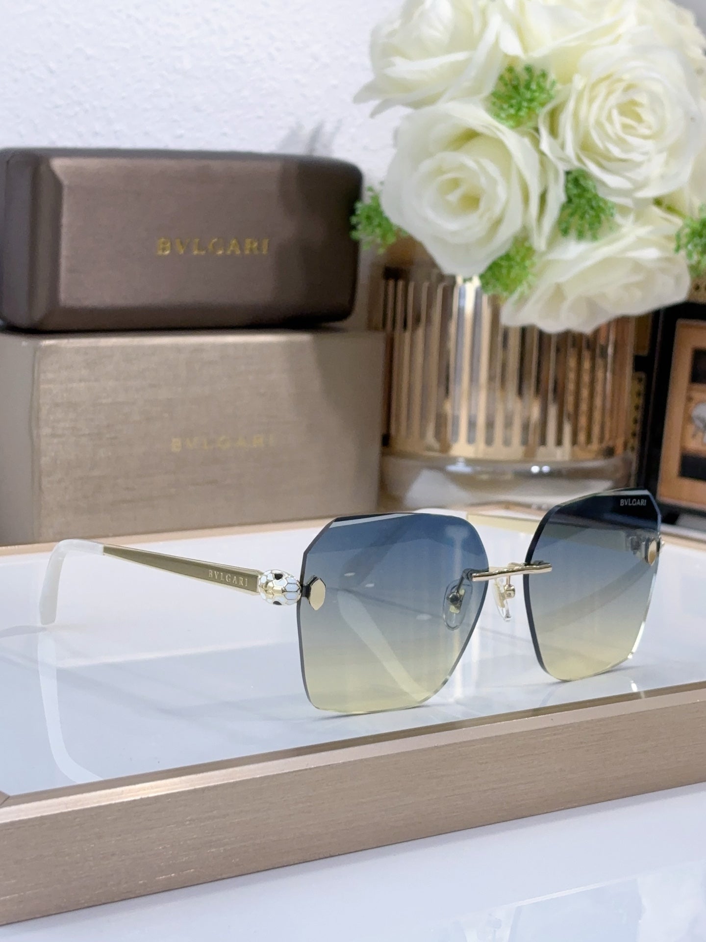 Bvlgari sunglasses with blue gradient lenses and gold-tone metal frame, side angle