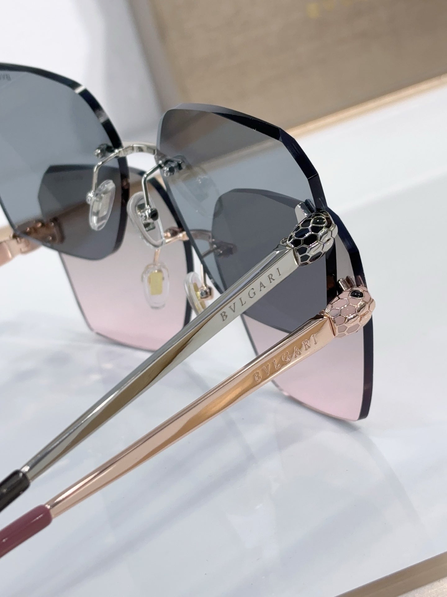 Bvlgari sunglasses close-up with black temples, gold-tone detailing, tinted lenses