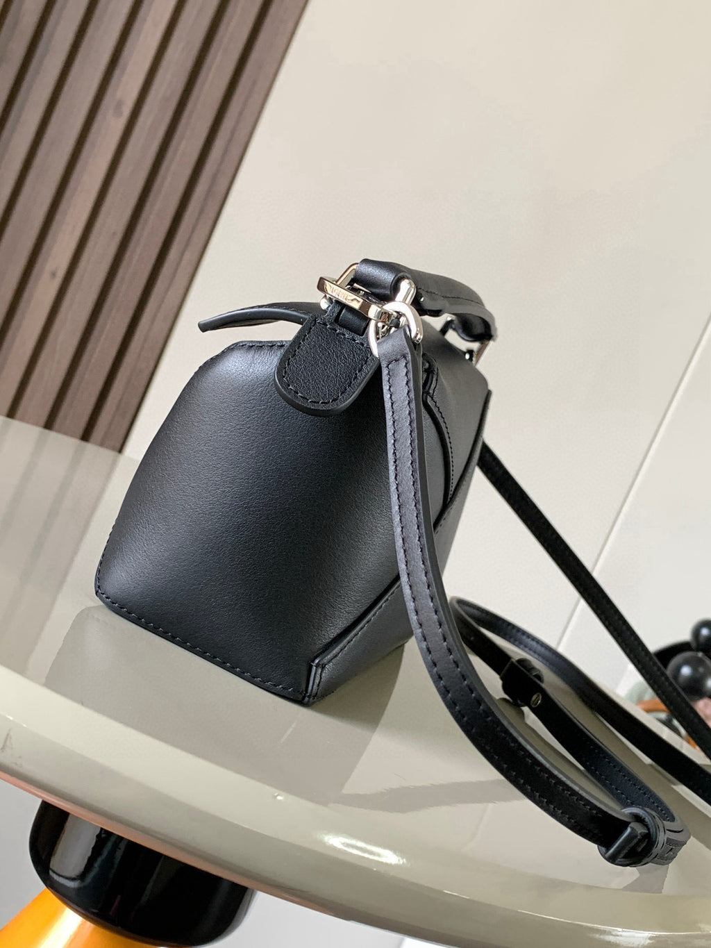Dark leather mini bucket bag with adjustable shoulder strap and silver metal hardware