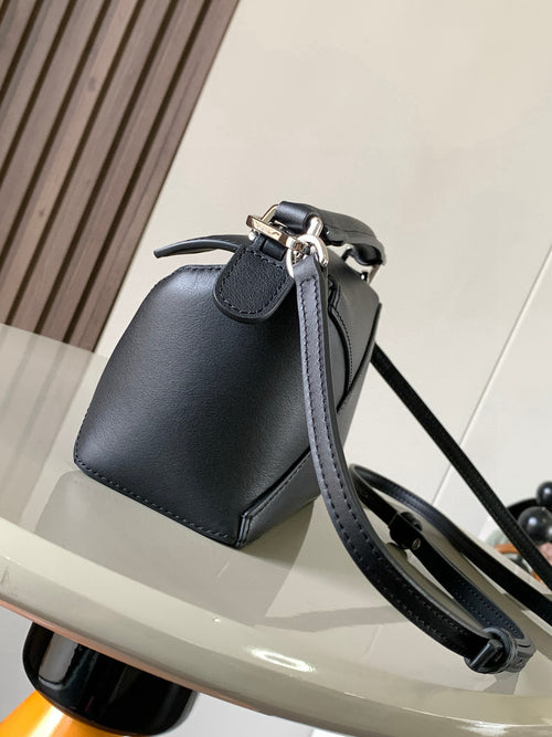 Dark leather mini bucket bag with adjustable shoulder strap and silver metal hardware