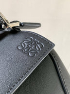 Loewe navy leather bag detail with embossed logo patch and stitched edge