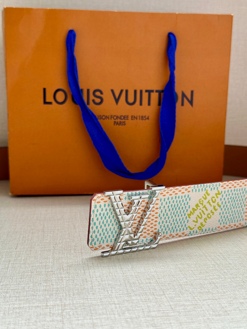 Louis Vuitton belt with gold buckle on turquoise-and-white patterned strap
