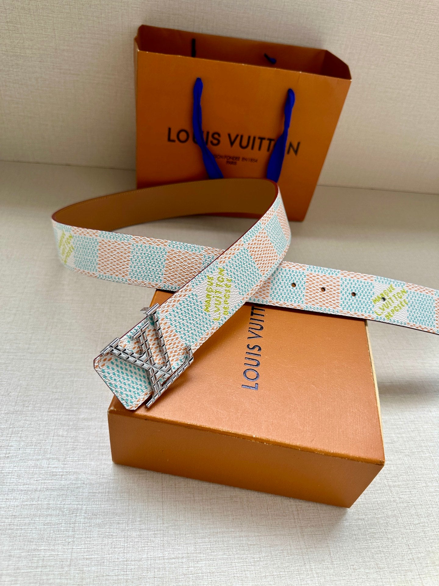 Louis Vuitton belt with turquoise-and-white patterned strap and gold-tone buckle