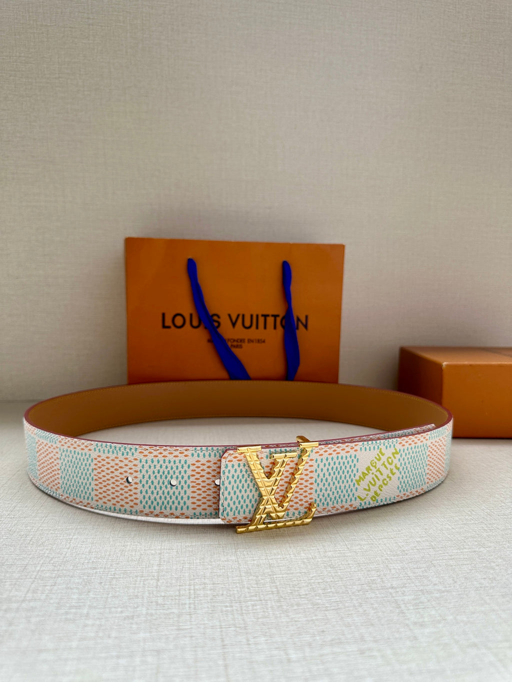 Louis Vuitton belt with turquoise-and-white patterned canvas strap and gold buckle