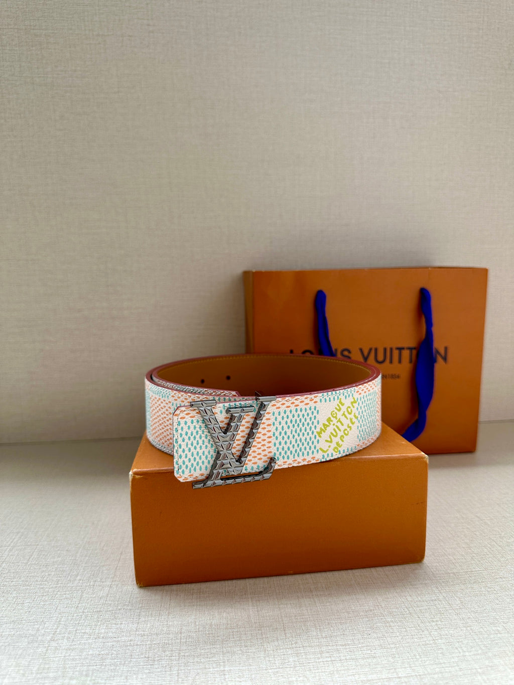Louis Vuitton belt with turquoise-and-white patterned strap and gold buckle