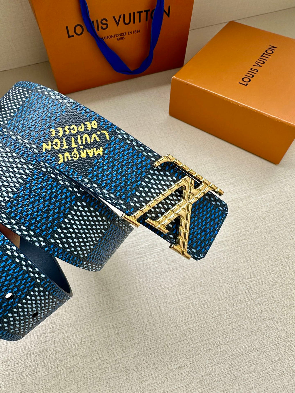 Blue patterned Louis Vuitton belt buckle detail with engraved silver hardware