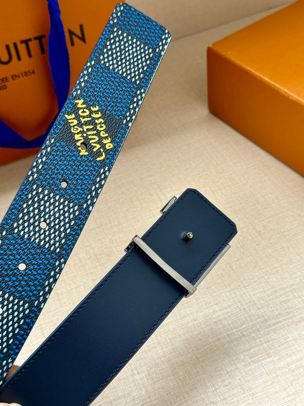 Blue Louis Vuitton belt with dark navy leather keeper and square silver buckle